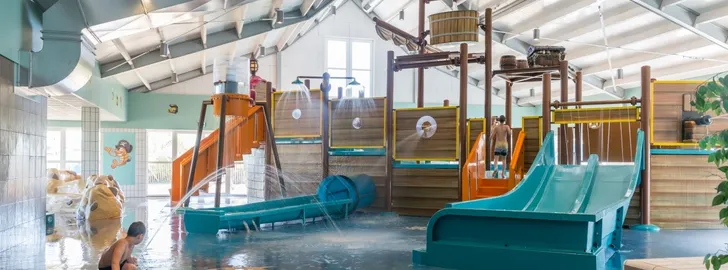 Overdekt zwembad met speelschip en spraypark