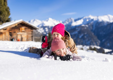 Kinderen spelen in de sneeuw op hoge berg in skigebied