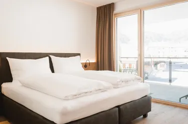 Moderne slaapkamer met tweepersoonsbed en balkon