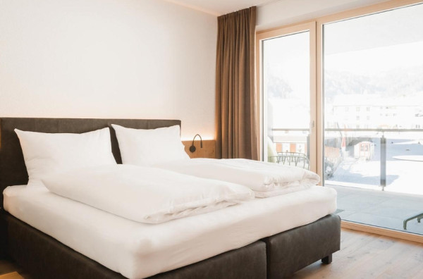 Moderne slaapkamer met tweepersoonsbed en balkon