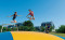 Kinderen maken hoge sprongen op de grote airtrampoline op Landal Beach Park Texel.