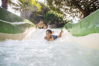 Twee jongens glijden over een wildwaterbaan in de aqua mundo van center parcs