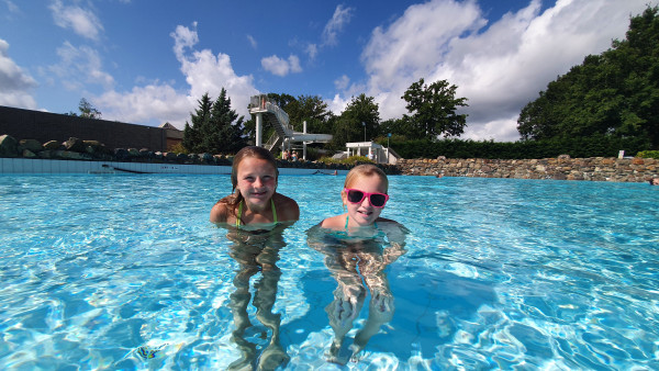 Kinderen staan in buitenzwembad bij Recreatiepark De leistert