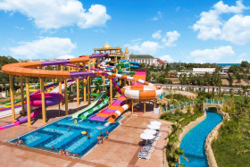 Overzicht van het grote waterpark van Delphin BE GRAND Resort in Lara, met veel kleurrijke glijbanen en een lazy river.