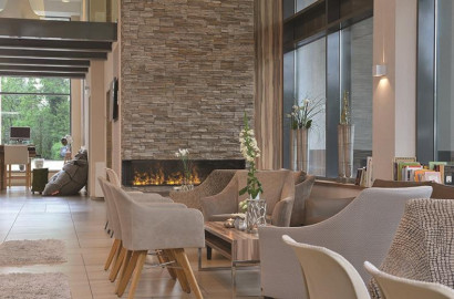 De sfeervolle lounge van Parkhotel Oberhausen met comfortabele stoelen en een gezellige open haard, ideaal voor families om te ontspannen.