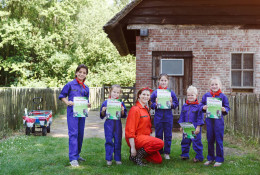 Kinderen in overall tonen trots hun boerderijdiploma op de kinderboerderij van Vakantiepark Dierenbos