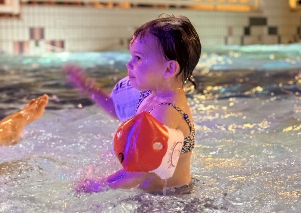 Baby speelt met bandjes om in het kinderzwembad