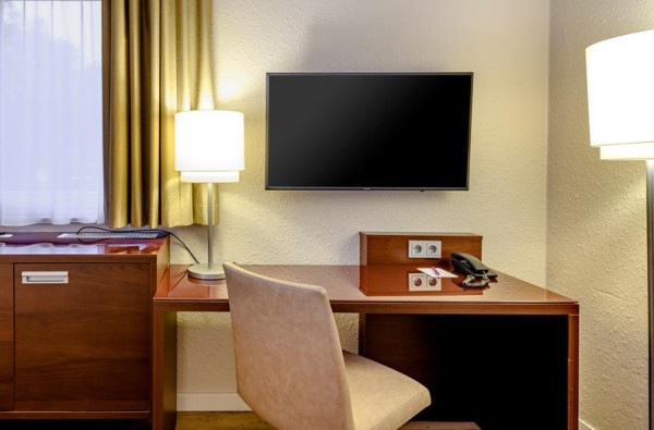 Bureau met televisie op een hotelkamer in Mercure Hotel Duisburg City