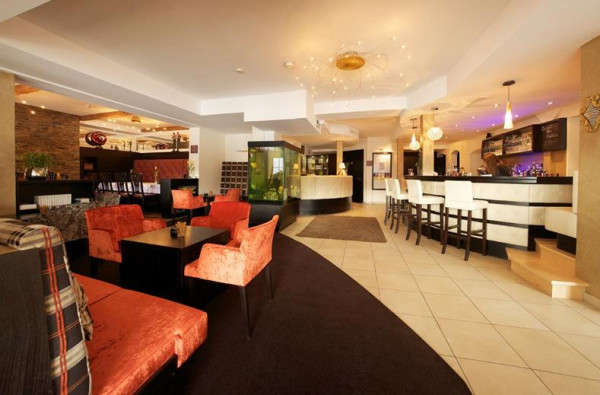 Ruimte met verschillende zithoeken en een bar in een hotel