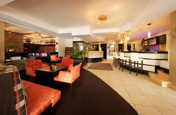 Ruimte met verschillende zithoeken en een bar in een hotel