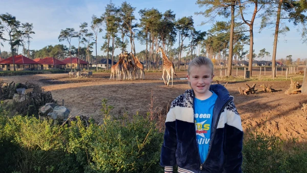 Kind poseert voor giraffen op Safari Resort Beekse Bergen
