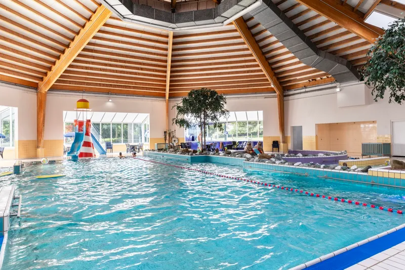Het overdekte zwembad van Vakantiepark Port Greve in Zeeland, met een grote waterglijbaan en een apart peuterbad.