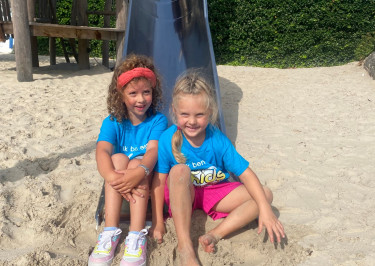 Kinderen zitten op de glijbaan bij De Zandstuve