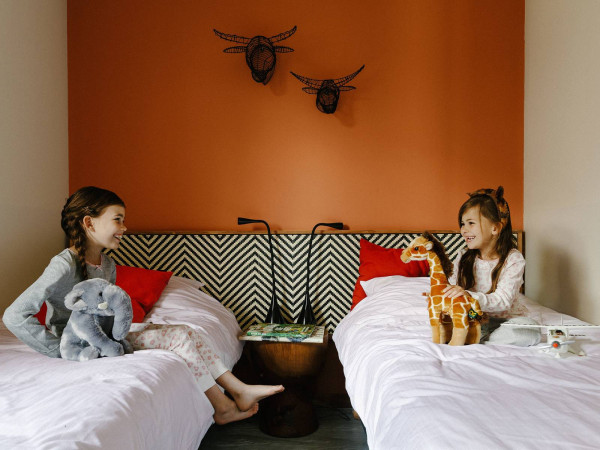 safari thema lodge met twee eenpersoonsbedden knuffeldieren en decoratieve wandkunst in Safari Resort Beekse Bergen