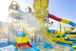 Een enorme emmer water kiept om over spelende kinderen in het waterpark