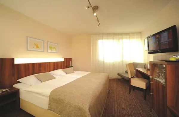 Hotelkamer in Parkhotel Oberhausen met een tweepersoonsbed bureau en flatscreen tv