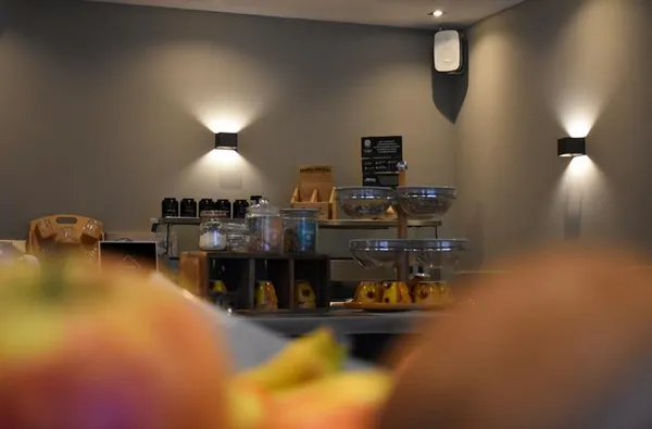 Het ontbijtbuffet van Hotel Atlanta met diverse ontbijtgranen en toppings onder sfeervolle moderne verlichting