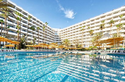 Het imposante hoofdgebouw van Hotel Eugenia Victoria weerspiegelt in het sprankelende zwembad! Met honderden kamers met balkon, gele parasols voor schaduw en een heerlijk zwembad is dit dé plek waar vakantiedromen uitkomen op Gran Canaria.