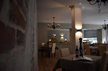 Chique restaurant in Hotel Atlanta met een rustieke bakstenen muur en een moderne inrichting in neutrale tinten