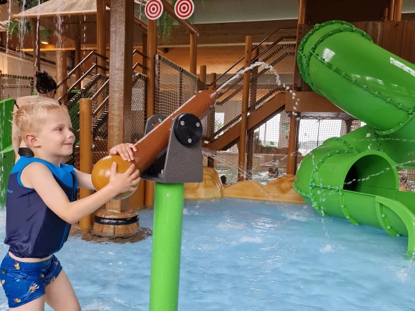 Kind speelt met waterspuit in indoor zwembad van Lake Resort Beekse Bergen