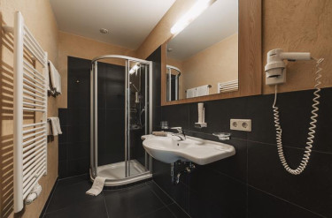 Comfortabele donkere badkamer met douchecabine en wastafel 