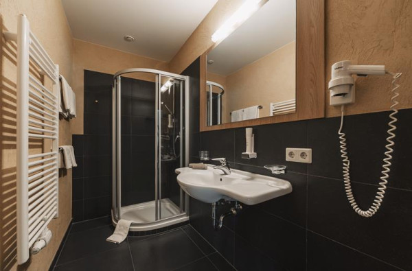 Comfortabele donkere badkamer met douchecabine en wastafel 