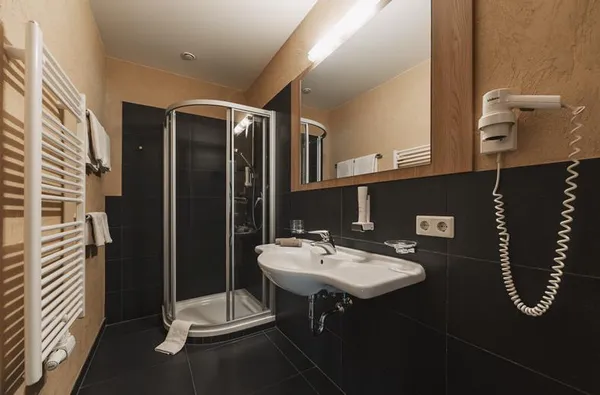 Comfortabele donkere badkamer met douchecabine en wastafel 