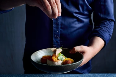 Een chef bereidt een culinair gerecht in restaurant Moto van het Safari Hotel Beekse Bergen