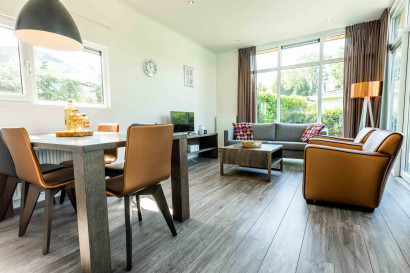 Het stijlvolle en moderne interieur van een vakantiewoning op Vakantiepark Leuvert, met een eethoek en een comfortabele zithoek.