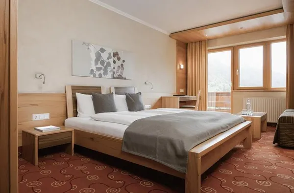 Tweepersoonsbed in appartement met uitzicht op de bergen