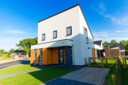 Een zes persoons witte vrijstaande vakantiebungalow met een tuin.