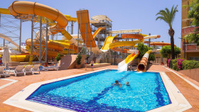 Het grote waterpark van hotel Pegasos World in Side met diverse gele en oranje waterglijbanen die uitkomen in het zwembad.