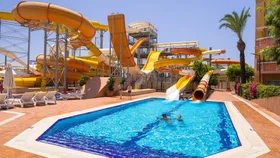 Het grote waterpark van hotel Pegasos World in Side met diverse gele en oranje waterglijbanen die uitkomen in het zwembad.