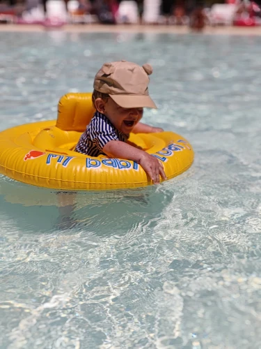 Baby drijft in een zwemband in het zwembad