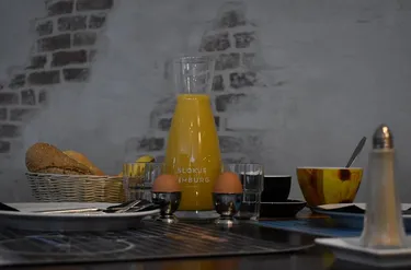 Uitgebreid ontbijt in Hotel Atlanta met een karaf verse jus d'orange gekookte eieren en broodjes tegen een sfeervolle bakstenen muur