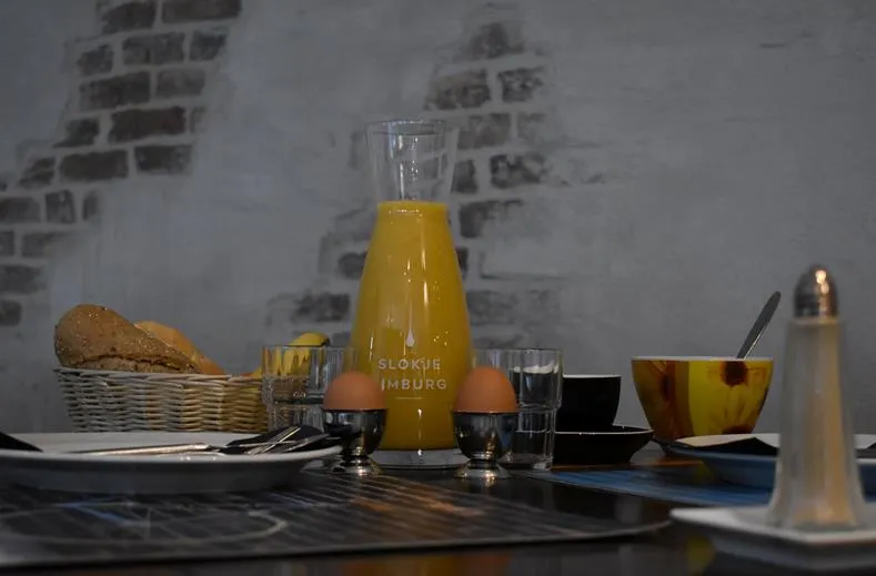 Uitgebreid ontbijt in Hotel Atlanta met een karaf verse jus d'orange gekookte eieren en broodjes tegen een sfeervolle bakstenen muur