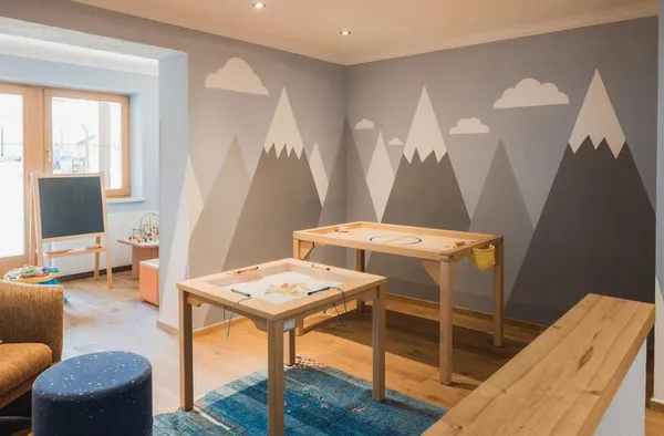 Speelkamer voor kinderen met speels behang en tafels met spelletjes