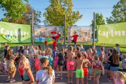 Een grote groep kinderen danst buiten mee met het enthousiaste animatieteam