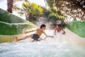 Twee jongens glijden over een wildwaterbaan in de aqua mundo van center parcs