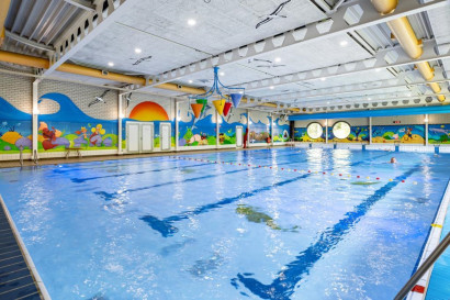 Het ruime binnenzwembad van Vakantiepark Hunzedal, met vrolijke wanddecoraties en ruimte om te zwemmen en te spelen voor het hele gezin.