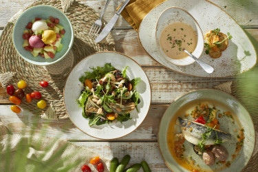 Verse gerechten geserveerd op houten tafel met zomerse presentatie bij restaurant van Lake Resort Beekse Bergen