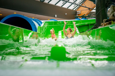 moeder en dochten glijden van de groene duo slide in het zwemparadijs van landal de lommerbergen