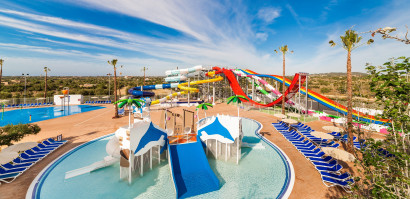 Waterpark met rode waterglijbanen en speeltoestellen bij Bouganvilla Hotel Appartementen Sa Coma Mallorca