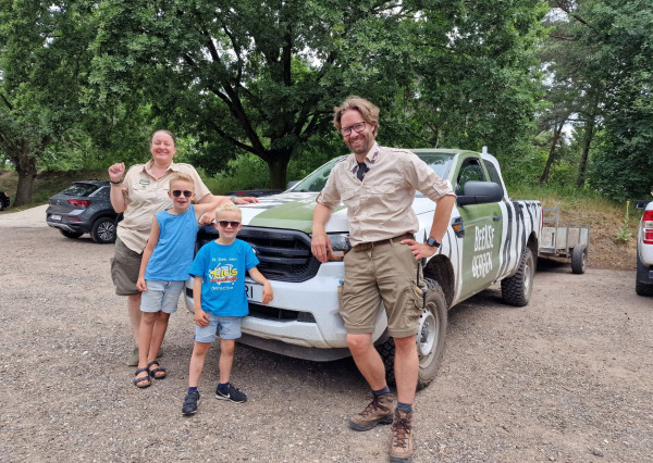 Kinderen staan met rangers voor de auto bij Safaripark Beekse Bergen