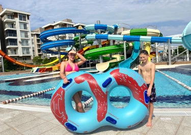 kinderen staan met grote band voor verschillende glijbanen in een waterpark in Turkije