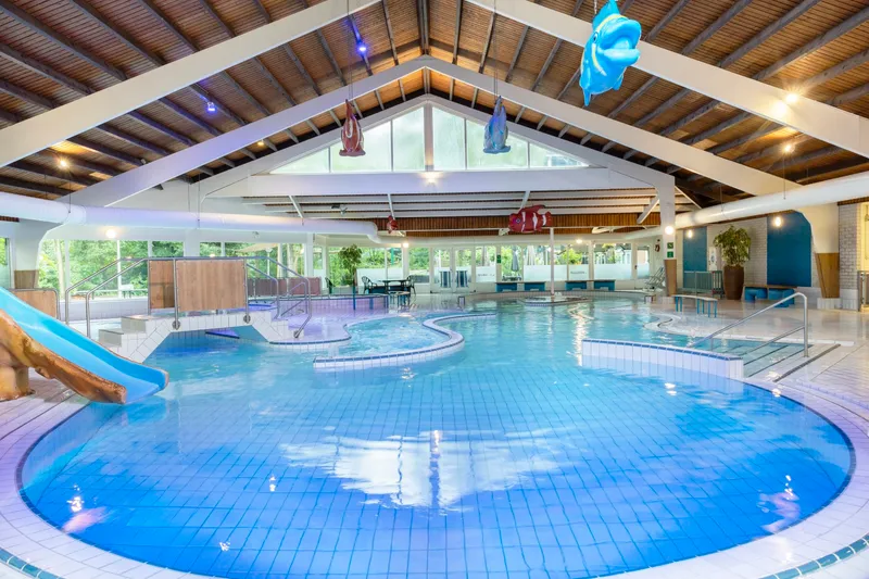Overzicht van het subtropische zwemparadijs Aqua Mundo op Parc Heihaas, met een groot zwembad en glijbaan.