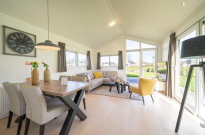 De lichte en moderne woonkamer van een vakantiewoning op EuroParcs Resort Limburg, met een ruime zithoek en eettafel.