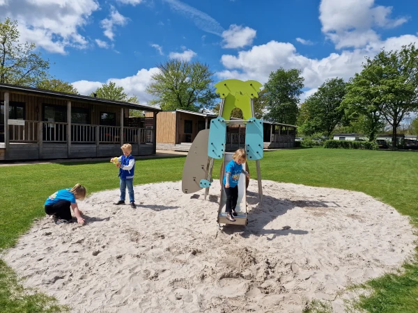 Kinderen spelen in buitenspeeltuin met zandbak bij vakantiepark TerSpegelt