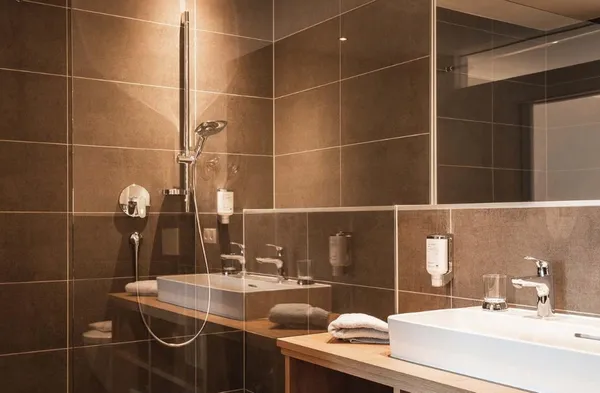 Moderne grijze badkamer met douche en wasbakken