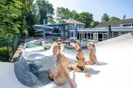 Tieners zitten op de rand van de skatebaan bij de halfpipe op het park